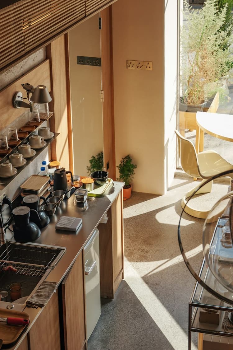 A modern kitchen counter with neatly arranged coffee supplies, grinder, and brewing equipment
